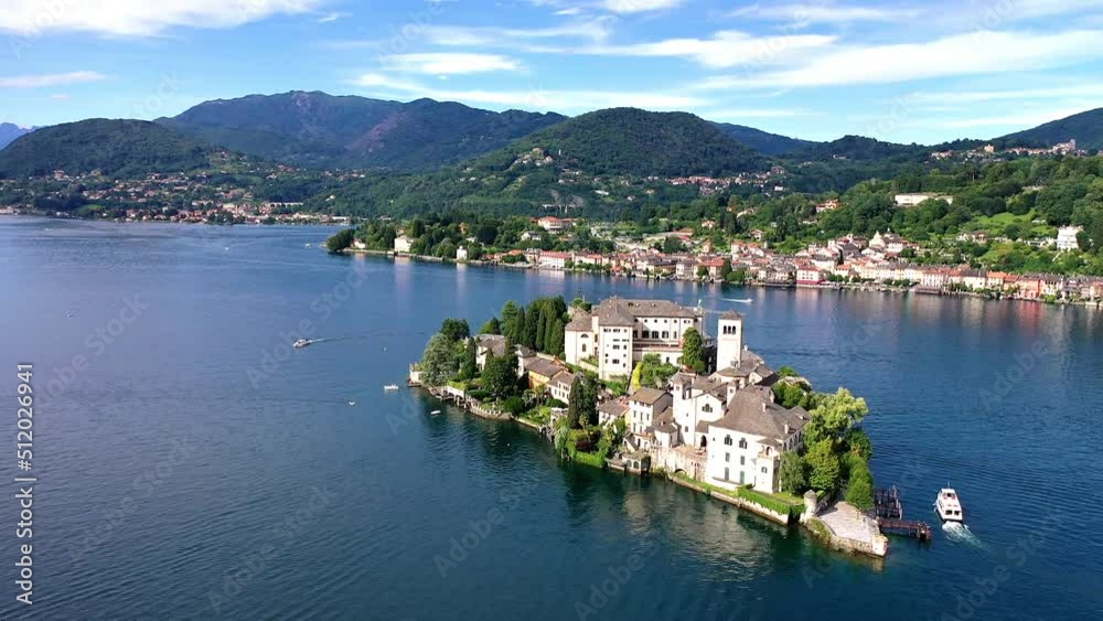 Flug über den Ortasee (Lago Orta) mit Blick über den See zur Insel San Giulio mit der mittelalterlichen historischen Basilika, Abtei und Kloster, Sommer, Sonne, blauer Himmel, Novara, Piemont, Italien