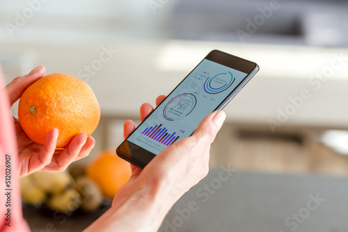 Woman holding smartphone with mobile app and orange photo