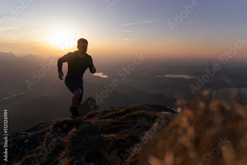 Silhouette hiker running on mountain at sunset photo