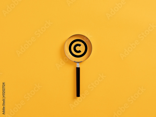 Magnifying glass magnifies copyright symbol. Patenting or copyright protection. photo