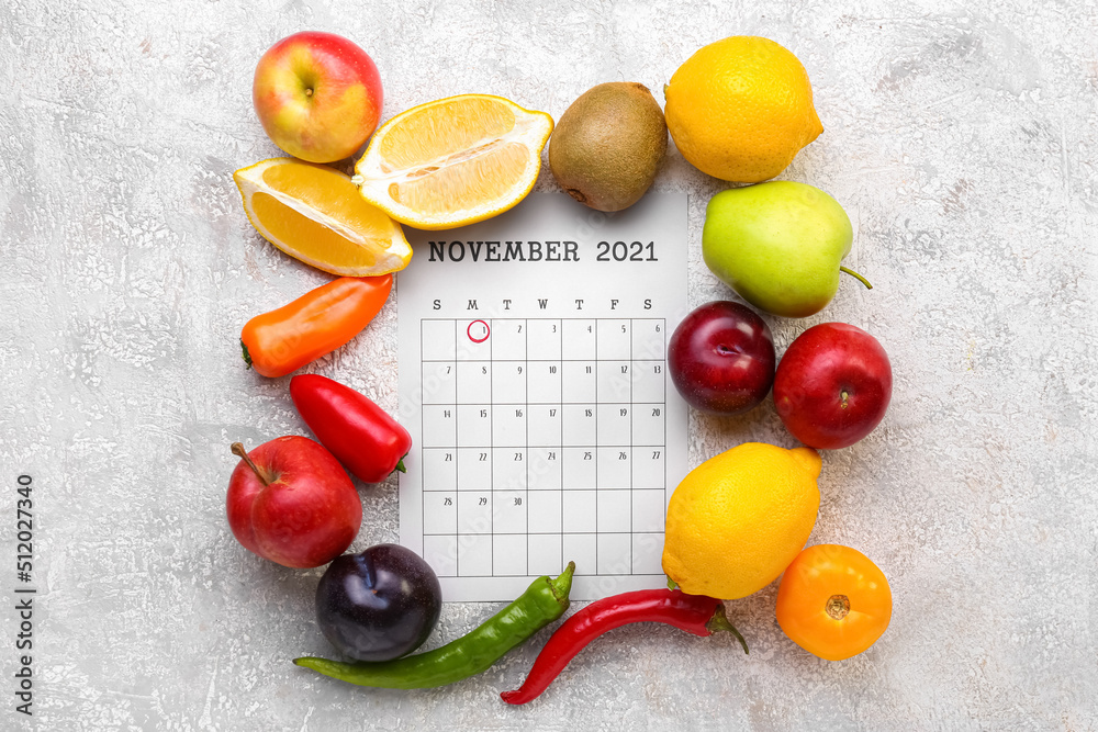 Calendar with marked date of World Vegan Day and fresh vegetables on