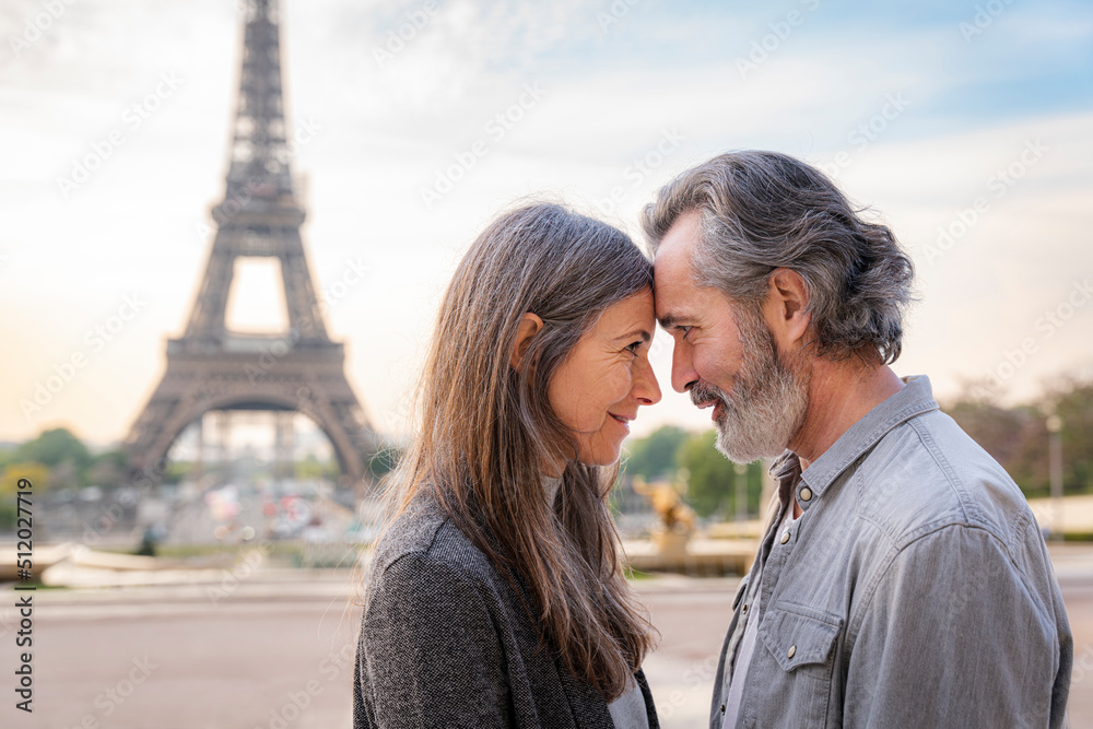 Smiling mature couple touching foreheads in front of Eiffel Tower, Paris, France Smiling mature couple touching foreheads in front of Eiffel Tower, Paris, France
