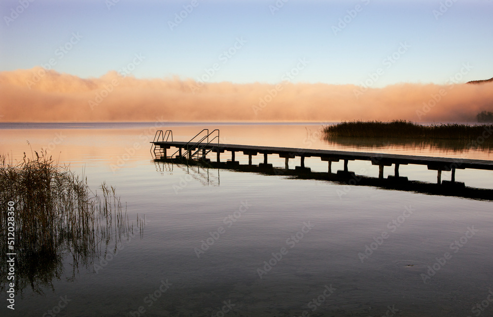 Austria, Upper Austria, Bathing jetty on shore of Mondsee lake with thick morning fog in background Austria, Upper Austria, Bathing jetty on shore of Mondsee lake with thick morning fog in background