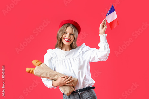 Beautiful young woman with flag of France and baguette on red background photo