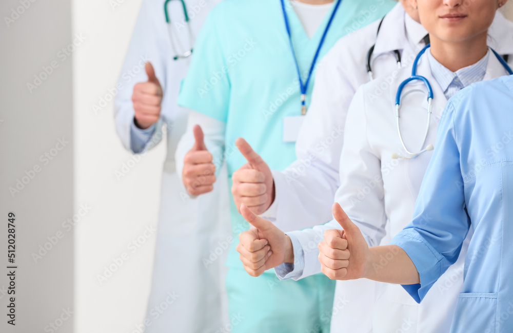 Group of doctors showing thumb-up in clinic Group of doctors showing thumb-up in clinic