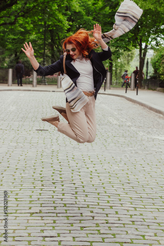 A picture of a woman jumping in an empty street