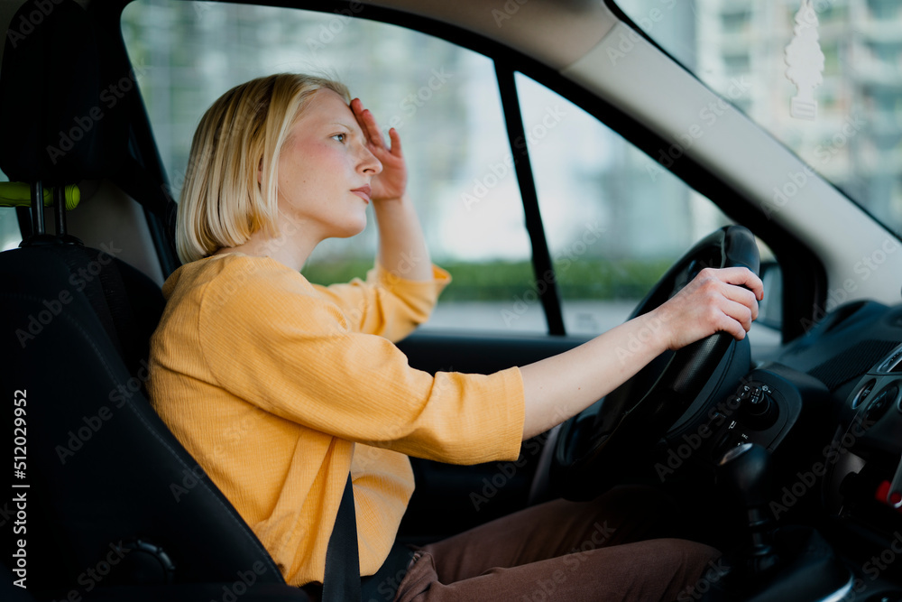 Angry woman driving a car. Upset young woman driving car in city Angry woman driving a car. Upset young woman driving car in city