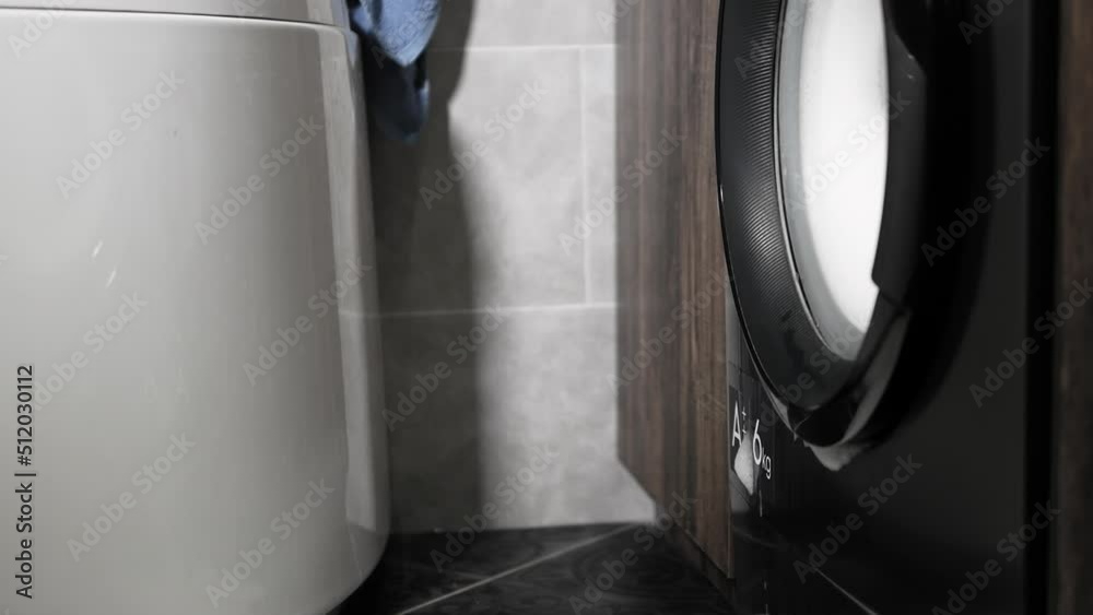 Broken washing machine, foam pouring from the drum of the washing