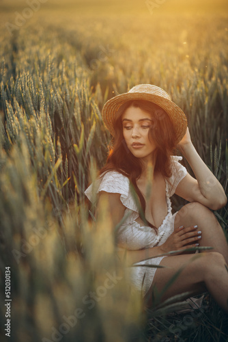 Woman in white dress sitting in the green field