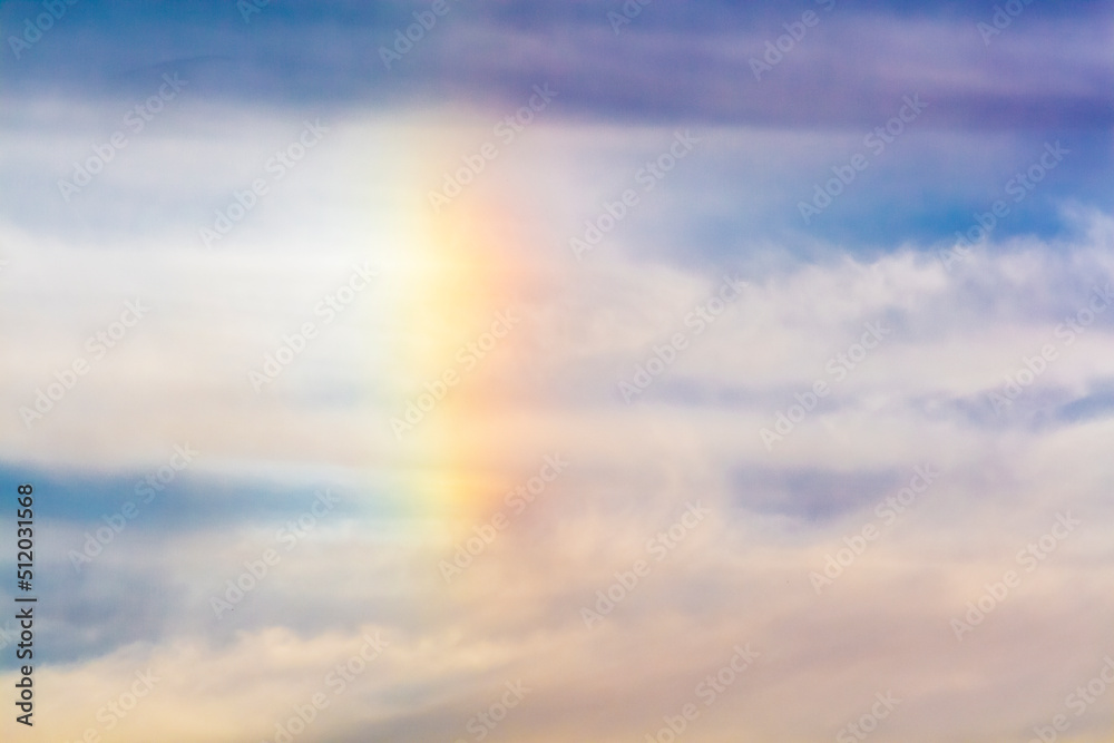 Rainbow in the clouds. Fragment of the natural phenomenon rainbow in the sky.