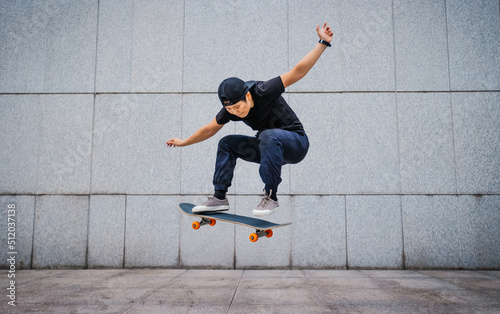 Asian woman skateboarder skateboarding in modern city photo