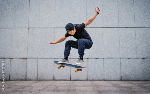 Asian woman skateboarder skateboarding in modern city