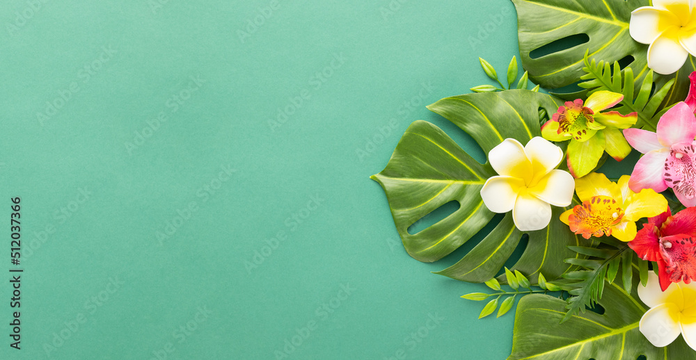 Summer background with tropical orchid flowers and green tropical palm leaves on green background. Flat lay, top view. Summer party backdrop - obrazy, fototapety, plakaty 