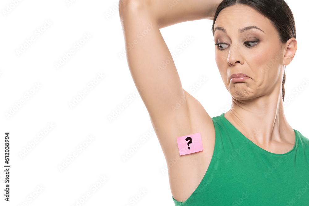 Woman shows her underarm with the question mark on her on white background Woman shows her underarm with the question mark on her on white background