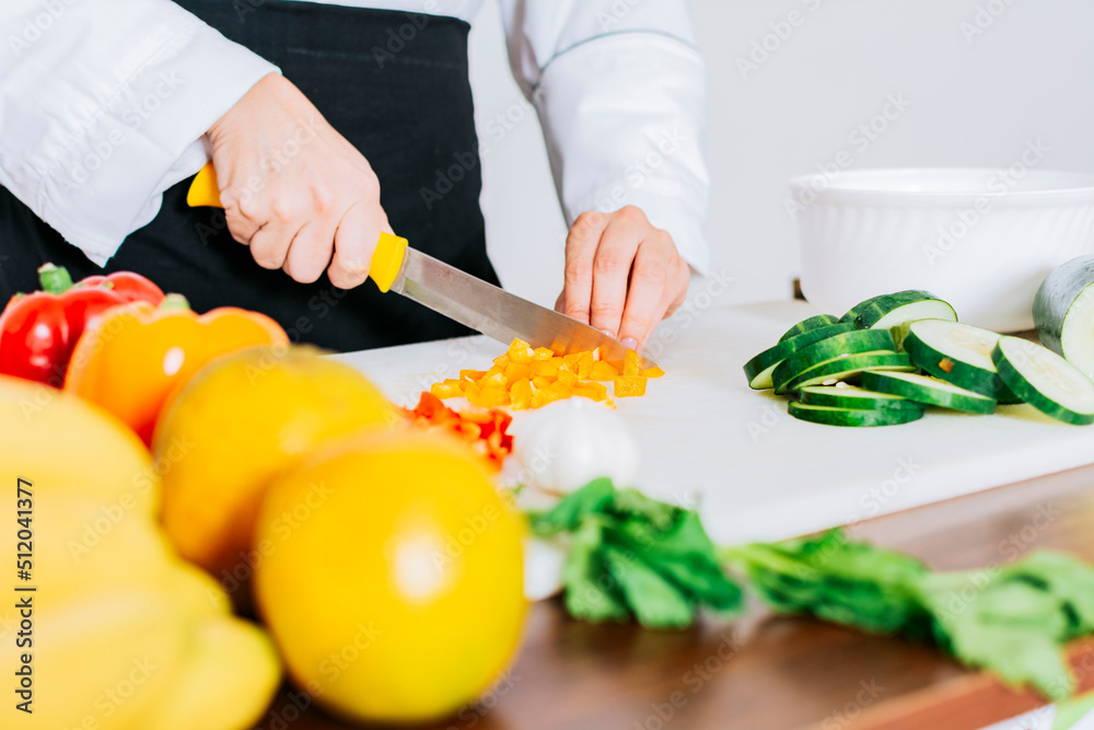 Close up of a female chef cutting vegetables, Hands of female chef cutting vegetables, chef hands preparing and cutting vegetables Close up of a female chef cutting vegetables, Hands of female chef cutting vegetables, chef hands preparing and cutting vegetables