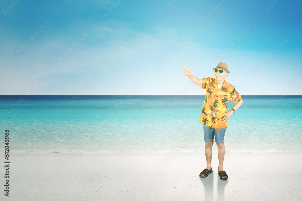 Senior man pointing at something on tropical beach