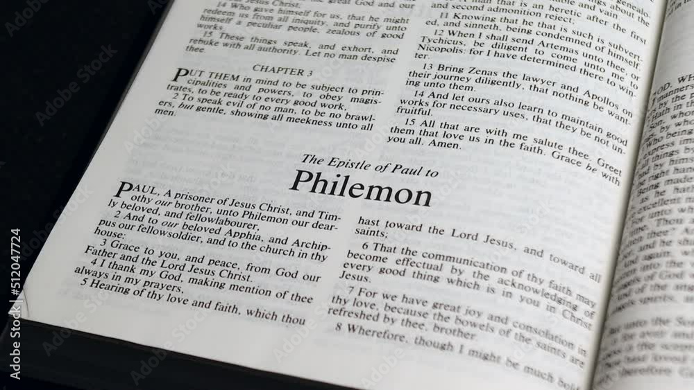 Close Up Shot of Bible Page Turning to the book of Philemon Close Up Shot of Bible Page Turning to the book of Philemon