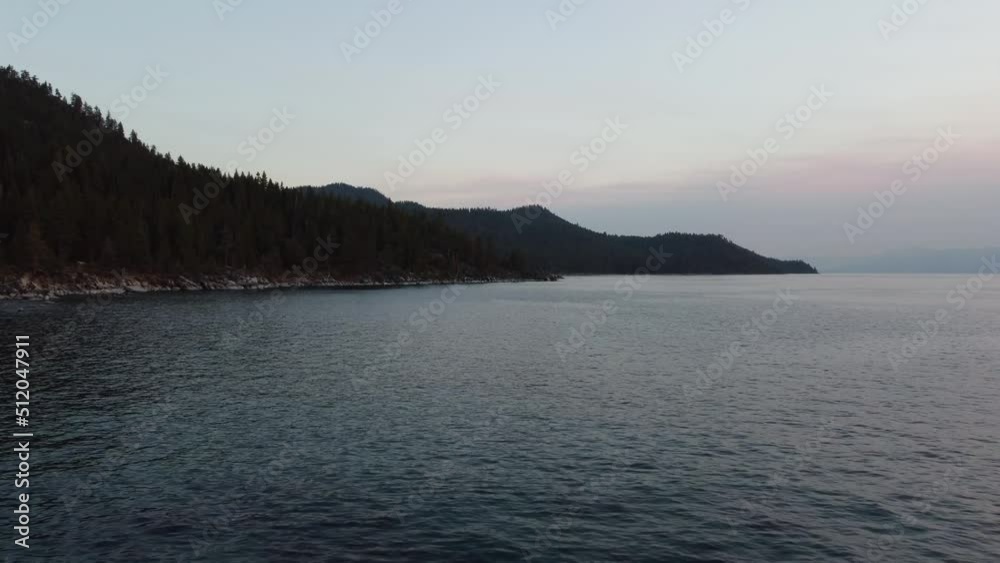Drone shot of the rocky Lake Tahoe shoreline with the forest in the background and the sun setting. This 4K cinematic wilderness scene was filmed using a DJI Mini 2 drone. Drone shot of the rocky Lake Tahoe shoreline with the forest in the background and the sun setting. This 4K cinematic wilderness scene was filmed using a DJI Mini 2 drone.