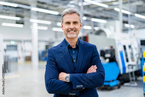 Portrait of confident mature businessman in factory photo