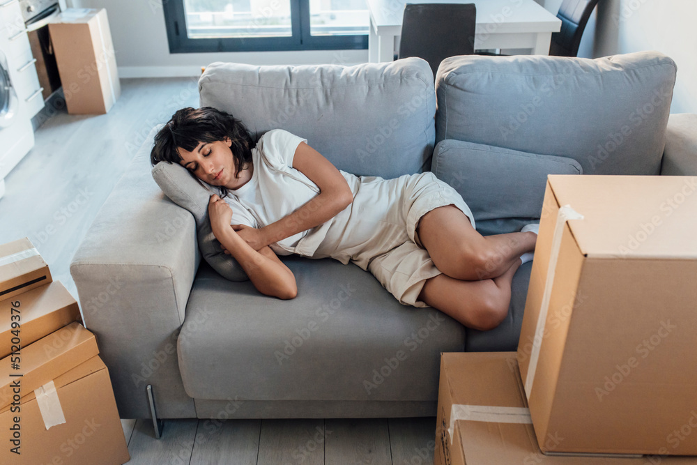 Woman sleeping on sofa in living room at new home Woman sleeping on sofa in living room at new home