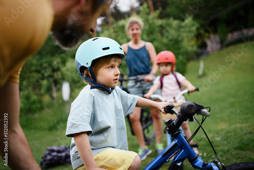 Young family with little children preaparing for bike ride, in front of house.