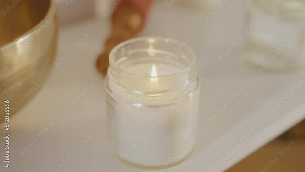 Close up lit white candle in transparent glass candlestick in spa salon beauty. Close up lit white candle in transparent glass candlestick in spa salon beauty.