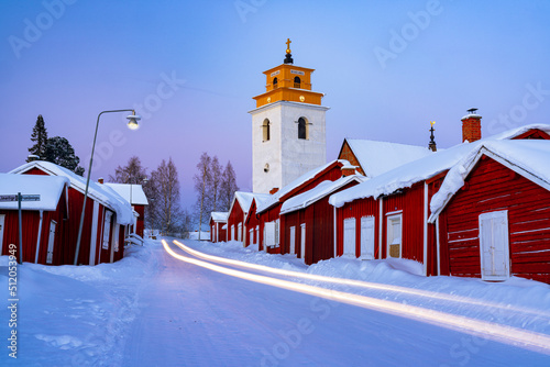 Car trails lights on the icy road crossing the medieval Gammelstad Church Town covered with snow, UNESCO World Heritage Site, Lulea, Sweden, Scandinavia photo