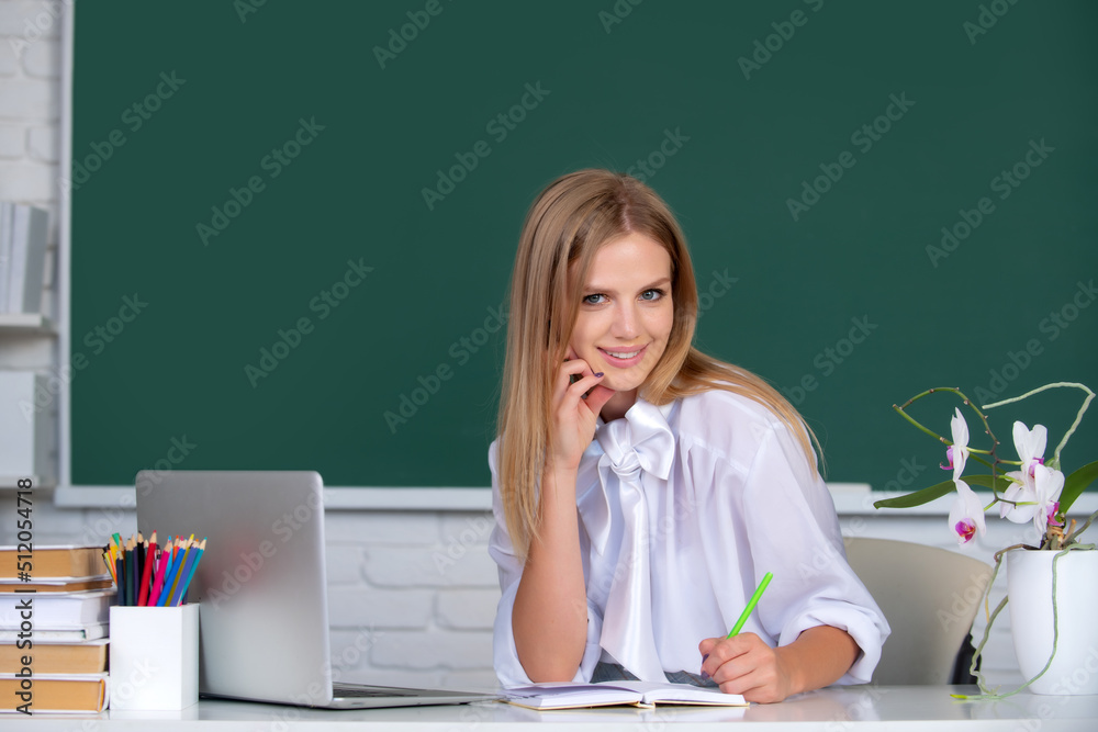 Fototapeta premium Female college student working on a laptop in classroom, preparing for an exam. Education, high school, university, learning and people concept.