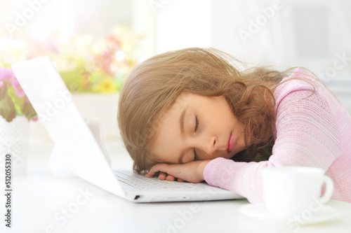 Portrait of cute little girl sleep with laptop