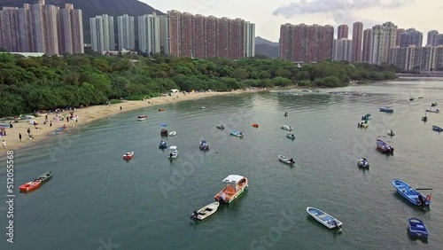 A dynamic aerial footage of various boats near the beach of Sai Kung town in Hong Kong. The Sai Kung peninsula is known for its quaint fishing villages and the tourists love their fresh seafood. photo