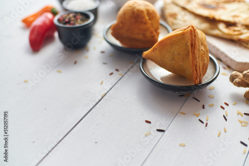 Traditional Indian Food snack Samosa served in a plate on a white wooden table