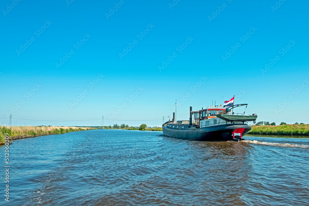 Freighter on the frisian canals in Friesland the Netherlands