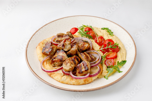 Pita with grilled chicken and hummus on a white background