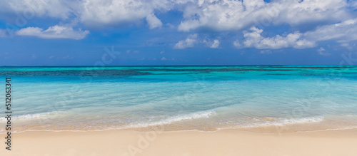 Closeup of sand on beach and blue summer sky. Panoramic beach landscape. Empty tropical beach and seascape. Blue sky, soft sand, calmness, tranquil relaxing sunlight, summer mood. Travel vacation 