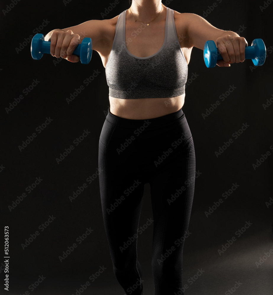 Close up image of fit women during exercise on the black background Close up image of fit women during exercise on the black background