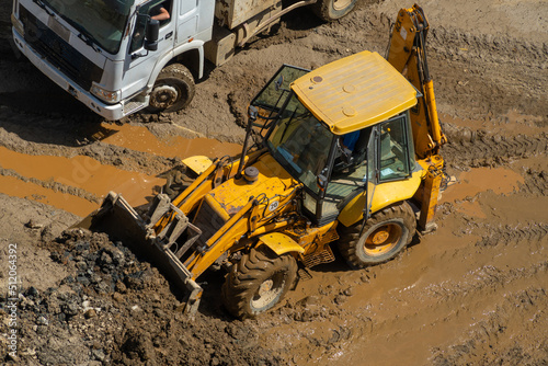 Wheel loader clears the site during excavation work on a construction site.Excavator with a front bucket removes the soil for backfilling at the construction site.Construction equipment for earthworks photo