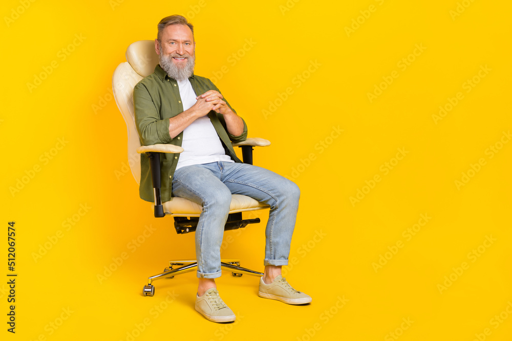 Full body portrait of cheerful aged person sitting chair have good mood isolated on yellow color background