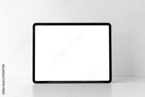 Front view of portable digital tablet computer with blank screen on white desk and background. Empty frame of tablet PC gadget for presentation and mockup with copy space.