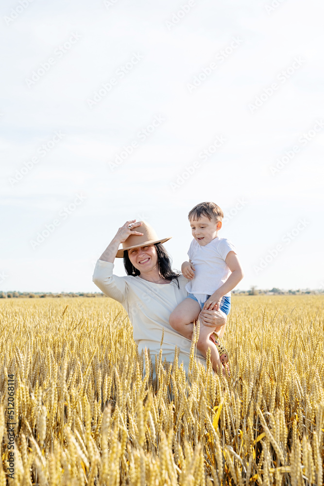 Happy family of mother and infant child walking on wheat field Happy family of mother and infant child walking on wheat field
