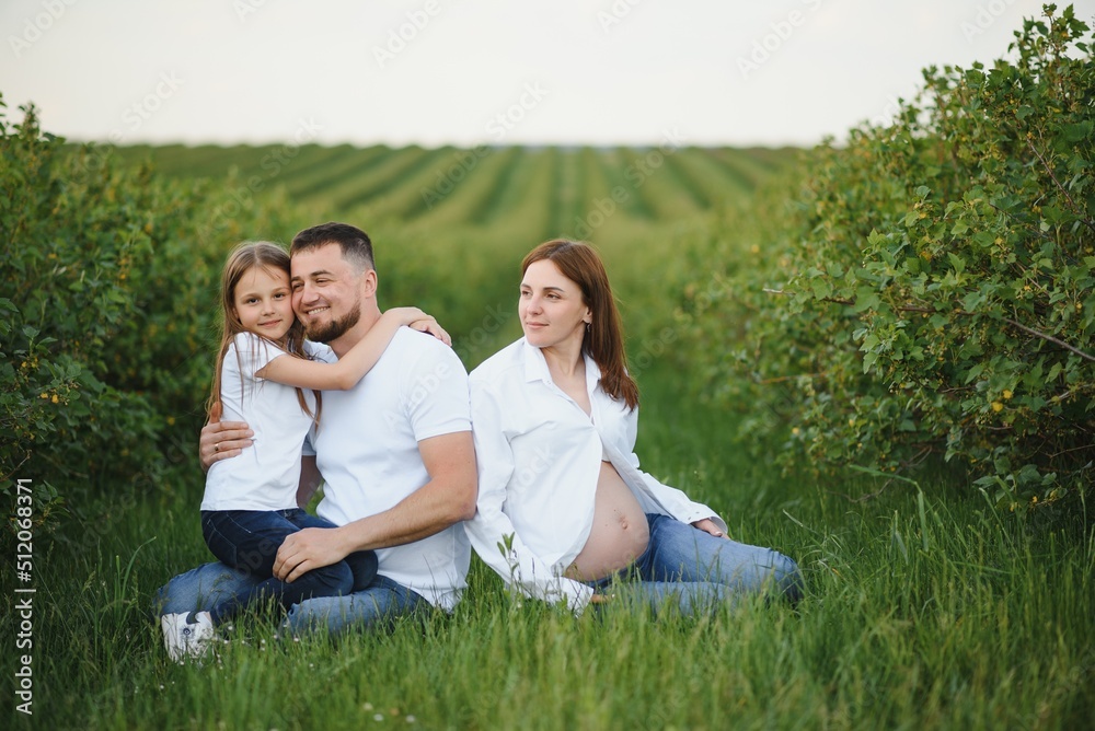 Pregnant woman with her family looking happy Pregnant woman with her family looking happy