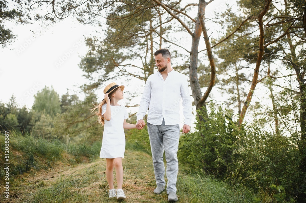 stylish bearded father with his little daughter walk in the summer park. stylish bearded father with his little daughter walk in the summer park.