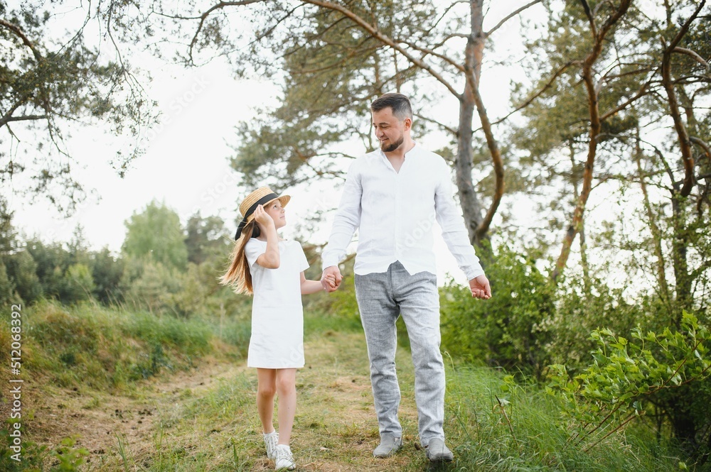 stylish bearded father with his little daughter walk in the summer park. stylish bearded father with his little daughter walk in the summer park.