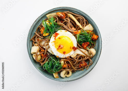 Plate with asian food - buckweet noodle with egg, mashrooms and vegetables