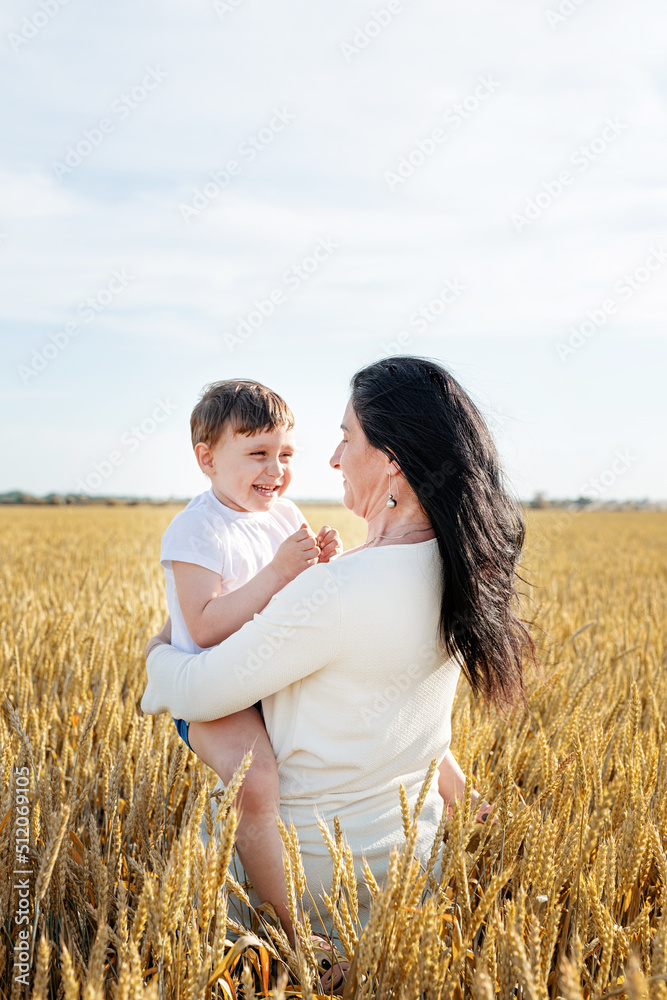 Happy family of mother and infant child walking on wheat field, family portrait Happy family of mother and infant child walking on wheat field, family portrait