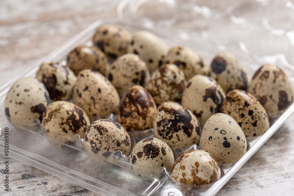 Quail eggs in plastic containers on a wooden table Quail eggs in plastic containers on a wooden table