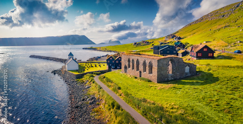 Panoramic summer view from flying drone of Kirkjubour village with Hestur Island on background. Captivating morning scene of Faroe Islands, Denmark, Europe. Traveling concept background..
