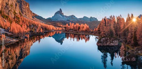 Panoramic autumn view from flying drone of popular tourist destination - Federa lake among red larch trees. Impressive sunrise in Dolomite Alps. Gorgeous morning scene of Italy, Europe. photo