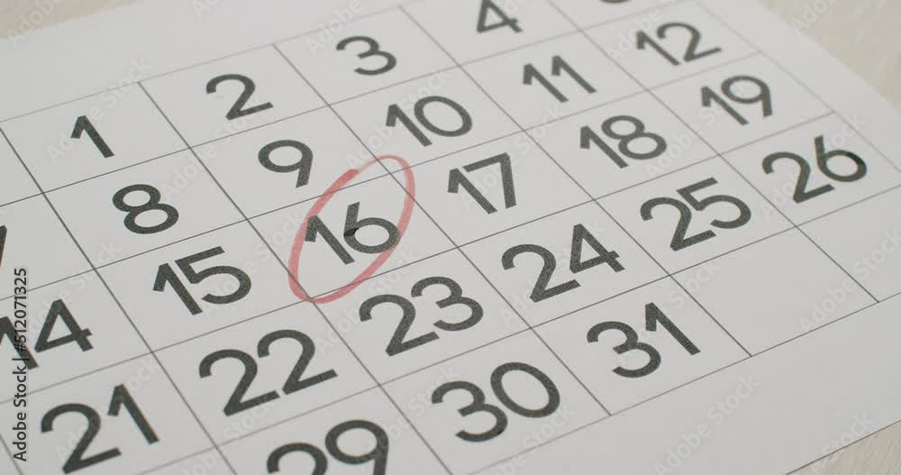  Very important date in the calendar. Signing a day on a calendar. Calendar 16th date of the month cut. Man's hand Write down the 16th day on the paper calendar using a red pen.