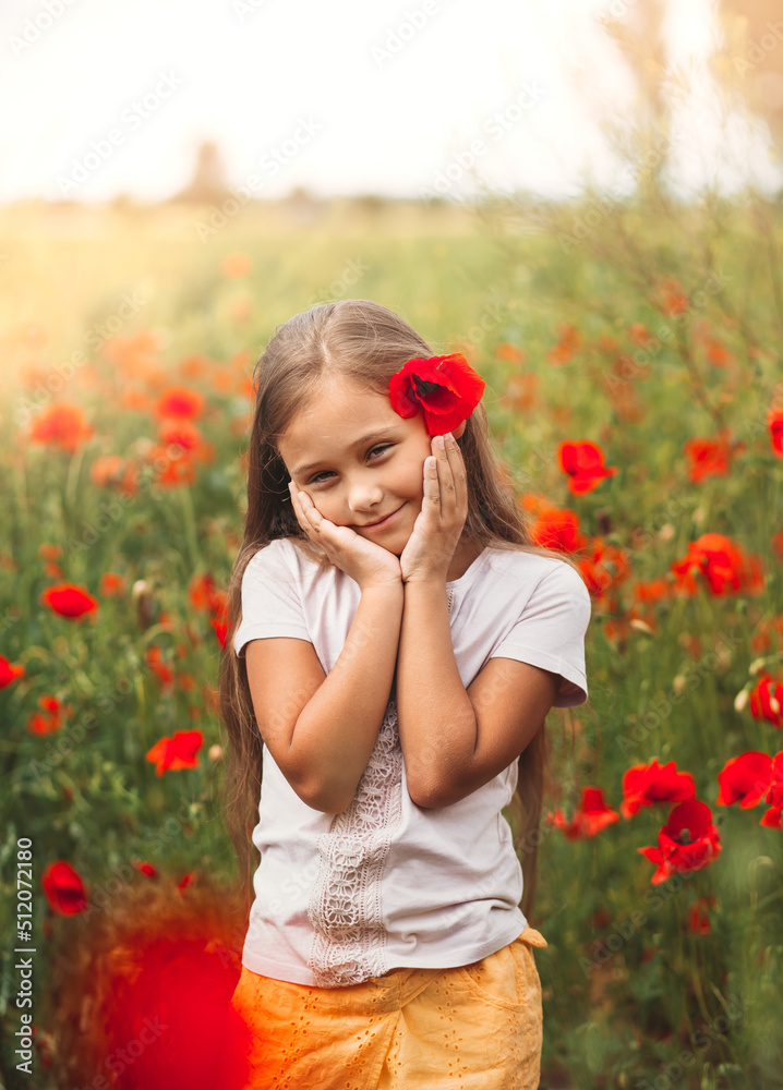 Little longhaired girl posing at field of poppies with on summer sun. Vertical Little longhaired girl posing at field of poppies with on summer sun. Vertical