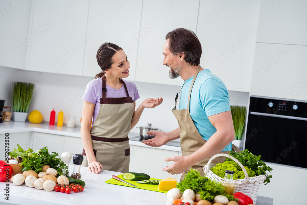 Photo of two positive peaceful partners communicate discuss recipe kitchen indoors